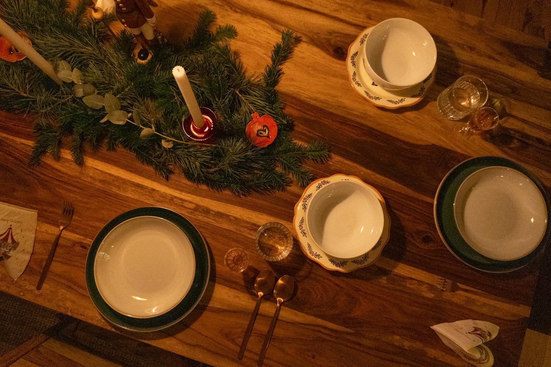 Świąteczny stół z świecami i gałązkami sosny na drewnianym blacie